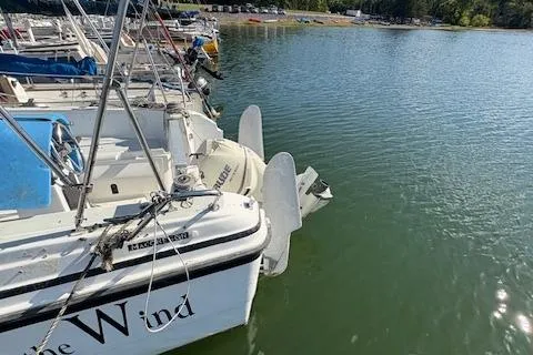 Slide: The Image of 1996 McGregor 26 sailboat docked on calm lake water. - 4