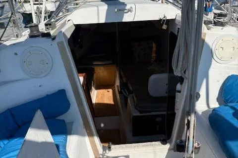 Slide: The Image of 1996 McGregor 26 sailboat interior with blue cushions and wooden accents. - 6