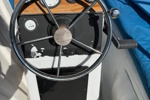 Slide: The Image of Steering wheel of a 1996 McGregor 26 boat with gauges and blue cover. - 7