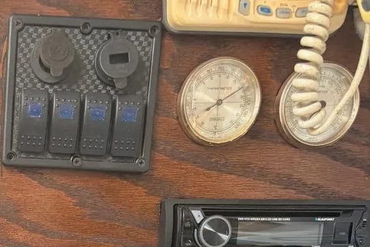 Slide: The Image of Control panel with switches, gauges, and radio on a 1996 McGregor 26 boat. - 8