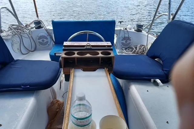 Slide: The Image of 1996 McGregor 26 sailboat cockpit with blue seating, steering wheel, and cup holders. - 9