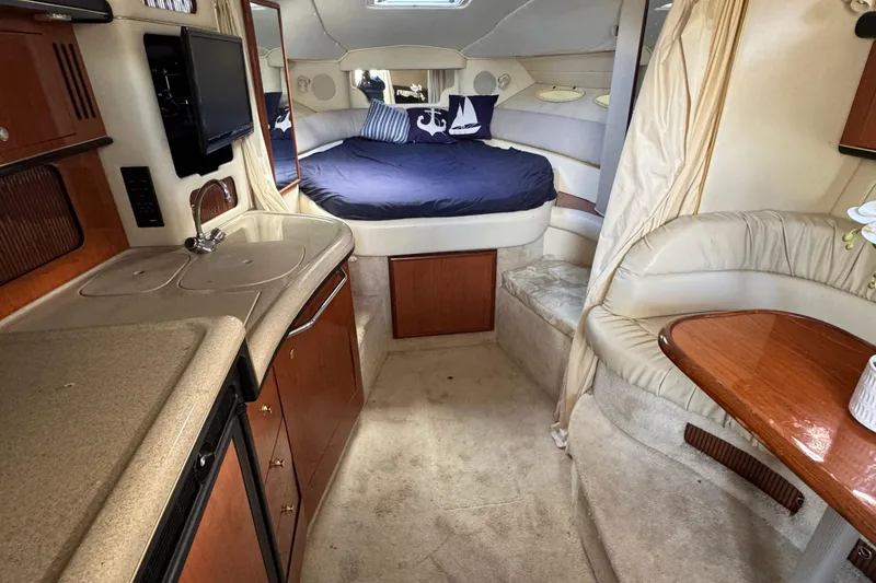 Slide: The Image of Interior of 1999 Searay 340 Sundancer yacht with kitchenette, bed, and seating area. - 10