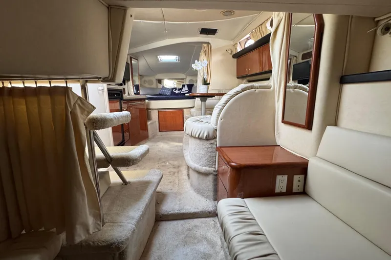 Slide: The Image of Interior of 1999 Searay 340 Sundancer yacht, featuring cozy seating and elegant decor. - 11