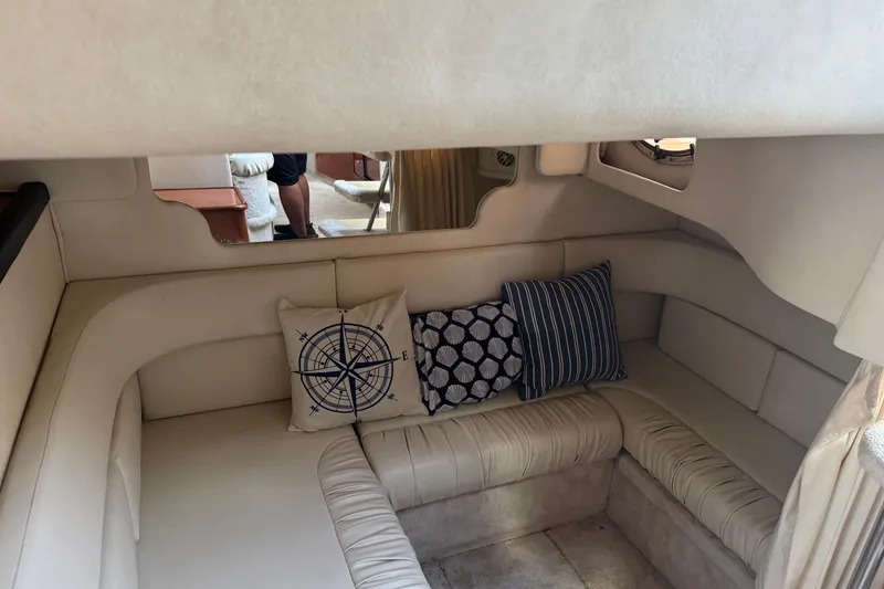 Slide: The Image of Interior of 1999 Searay 340 Sundancer with beige seating and decorative pillows. - 12