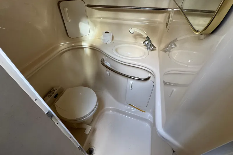 Slide: The Image of 1999 Searay 340 Sundancer bathroom with toilet, sink, and mirror. - 13