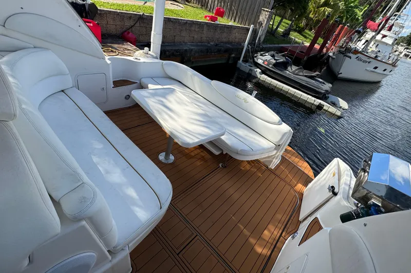 Slide: The Image of 1999 Searay 340 Sundancer boat interior with white seating and wooden deck. - 4