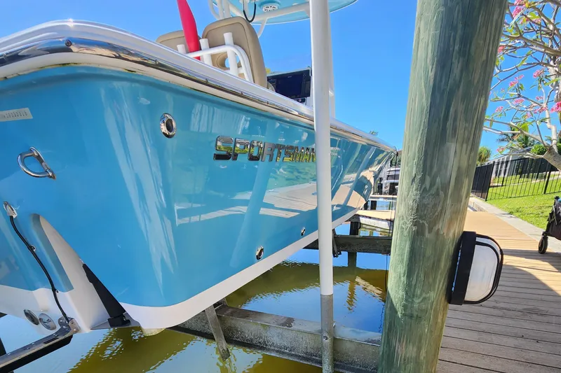 Slide: The Image of 2018 Sportsman Masters 247 Bay Boat docked, showcasing sleek blue design and branding. - 1