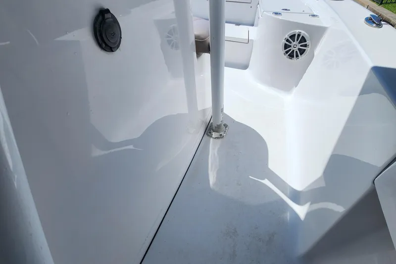 Slide: The Image of 2018 Sportsman Masters 247 Bay Boat interior, featuring clean white deck and speaker. - 11