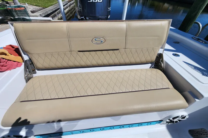 Slide: The Image of 2018 Sportsman Masters 247 Bay Boat beige seating with quilted design, docked by water. - 16