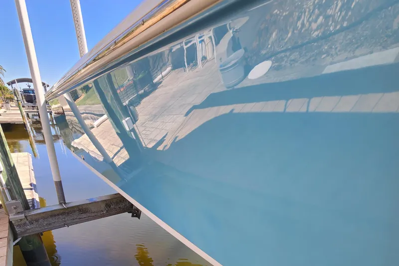 Slide: The Image of 2018 Sportsman Masters 247 Bay Boat with glossy blue hull at dockside. - 2