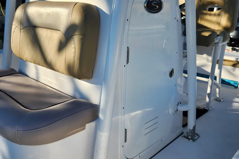 Slide: The Image of 2018 Sportsman Masters 247 Bay Boat interior with beige seating and storage compartment. - 23