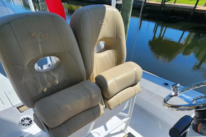 Slide: The Image of 2018 Sportsman Masters 247 Bay Boat seats with beige upholstery near water. - 4