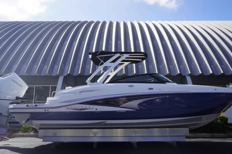 Slide: The Image of 2026 Monterey M-65 boat displayed outdoors with modern architecture backdrop. - 1