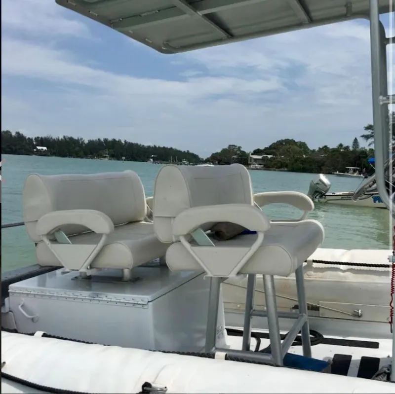 Slide: The Image of 2001 Willard 25 boat with white cushioned seats on a calm lake. - 10