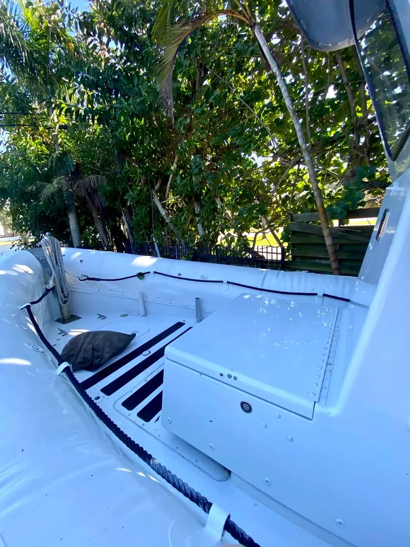 Slide: The Image of 2001 Willard 25 boat interior with seating and storage, surrounded by lush greenery. - 11