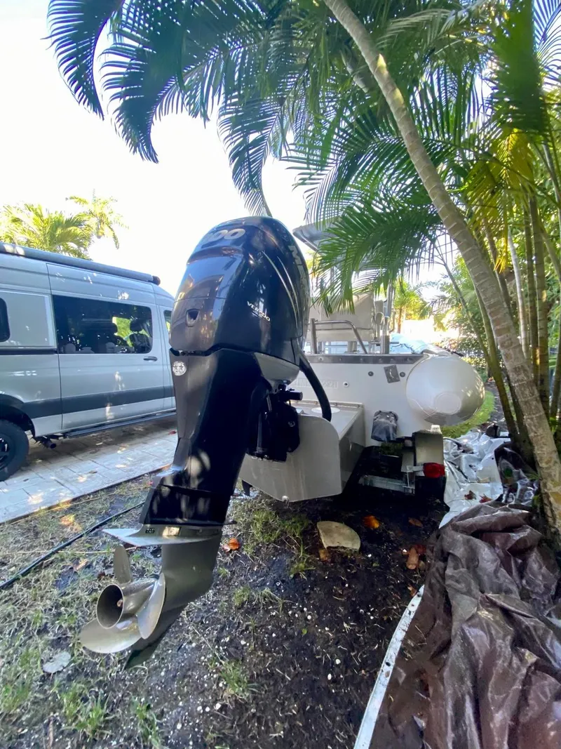 Slide: The Image of 2001 Willard 25 boat with outboard motor parked near palm trees. - 16