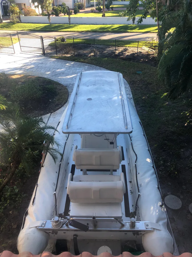 Slide: The Image of 2001 Willard 25 boat parked outdoors, surrounded by greenery and a paved walkway. - 18