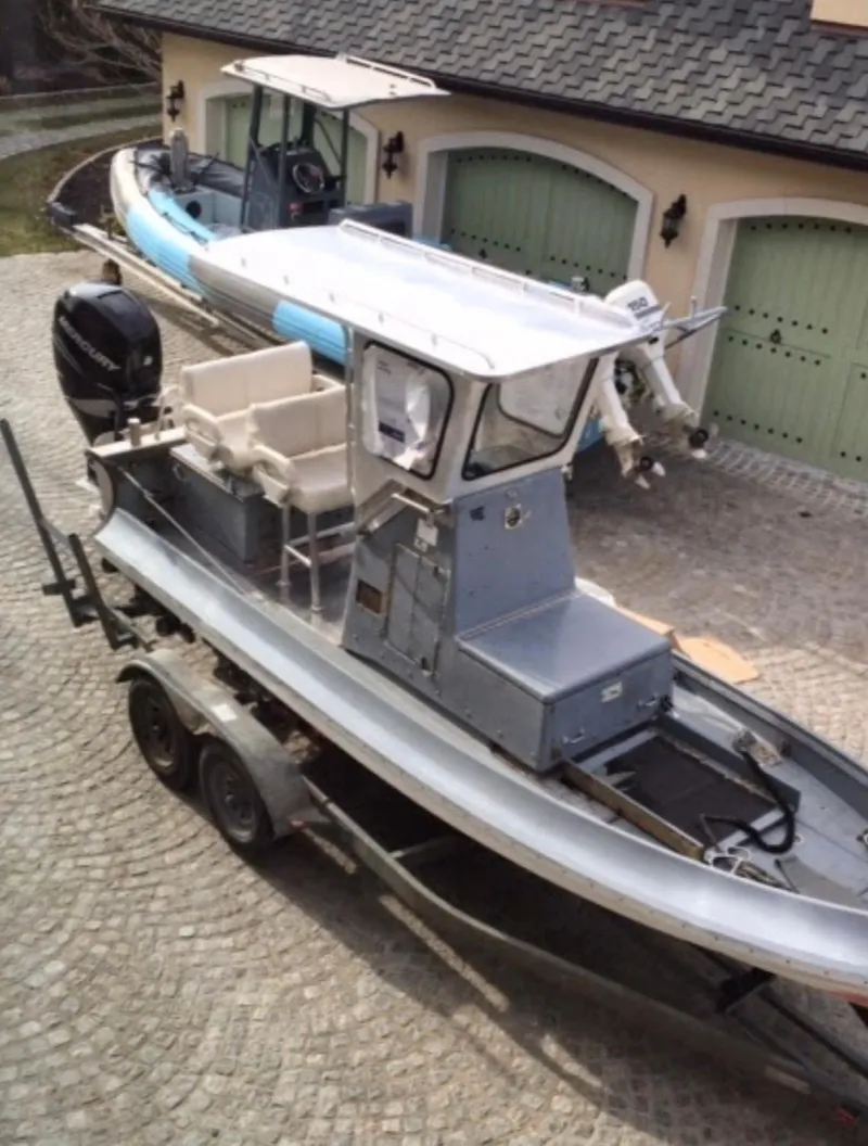 Slide: The Image of 2001 Willard 25 boat on a trailer in a driveway. - 2