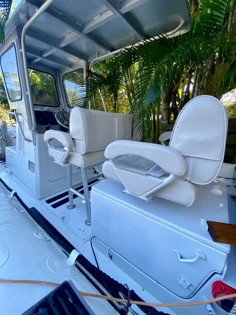 Slide: The Image of 2001 Willard 25 boat interior with white captain's chairs and control console. - 4