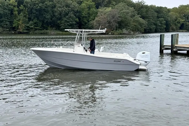 The Image of 2026 Bulls Bay 230 Center Console boat on a calm lake near a dock. - 0