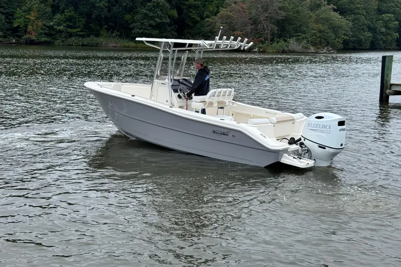 Slide: The Image of 2026 Bulls Bay 230 Center Console boat on a calm river with Suzuki engine. - 3