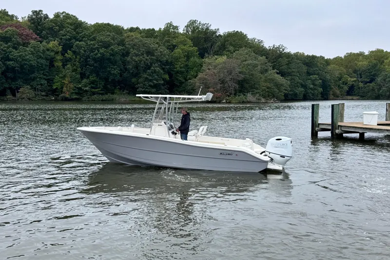 Slide: The Image of 2026 Bulls Bay 230 Center Console boat on a calm river near a dock. - 4