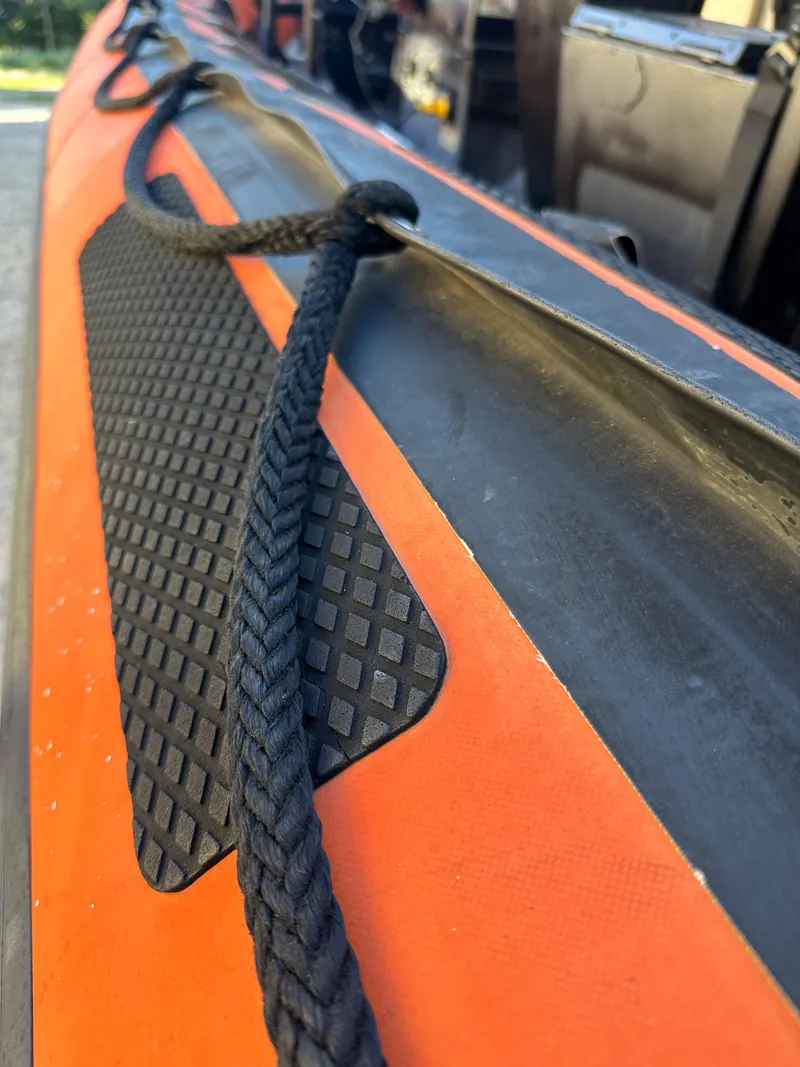 Slide: The Image of Close-up of a 2008 Zodiac 24 boat with black rope and orange detailing. - 6