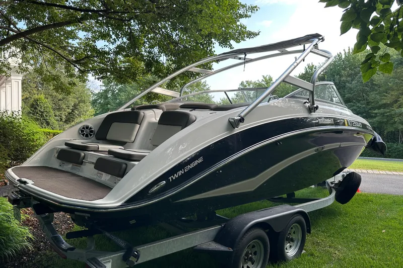 Slide: The Image of 2012 Yamaha Boats 242 Limited S on trailer, parked in a lush green setting. - 16