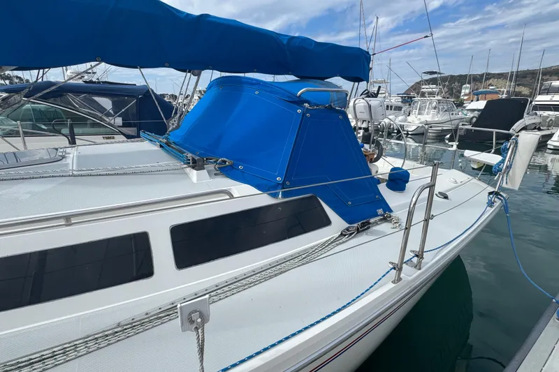 Slide: The Image of 1994 Catalina 320 sailboat with blue canopy docked in marina. - 11
