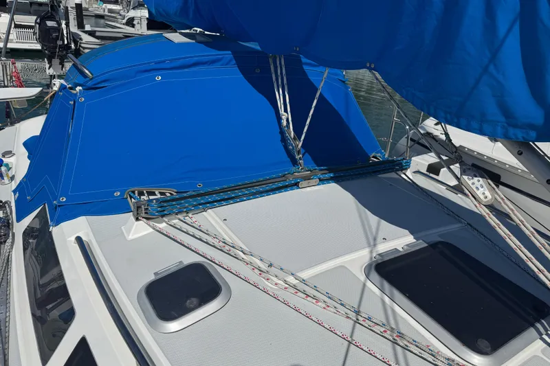 Slide: The Image of 1994 Catalina 320 sailboat with blue canvas cover and rigging details. - 12