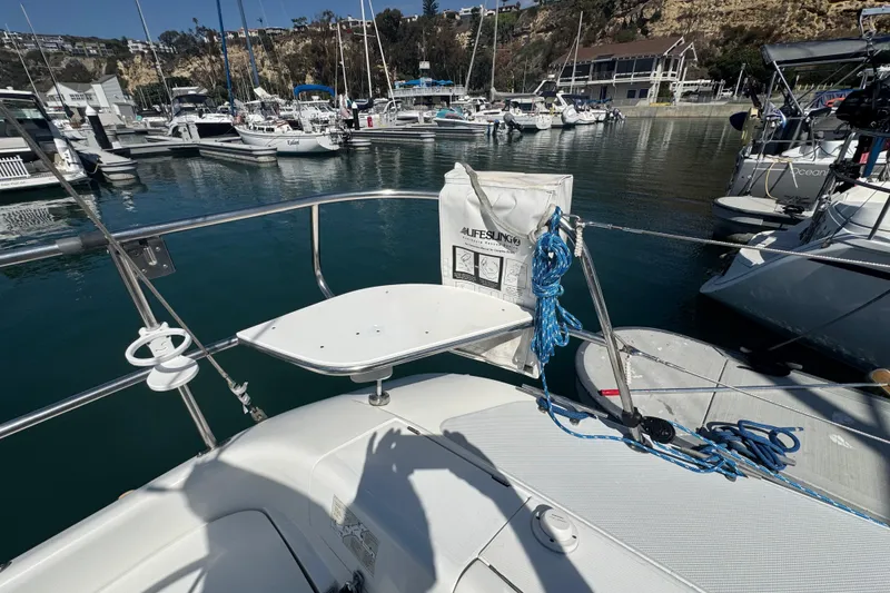 Slide: The Image of Sailboat Catalina 320, 1994 model, docked in marina with lifebuoy and ropes. - 17