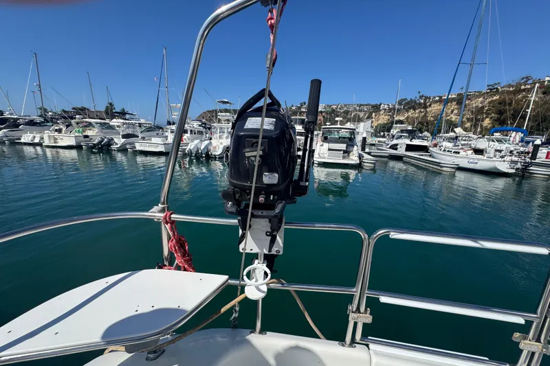 Slide: The Image of Catalina 320 sailboat in marina, showcasing outboard motor and scenic harbor view. - 19