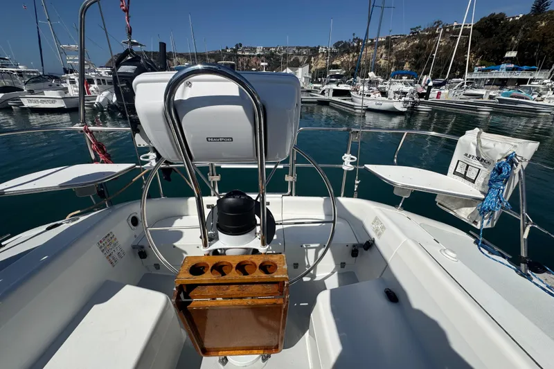Slide: The Image of Cockpit of a 1994 Catalina 320 sailboat docked in a marina, featuring a steering wheel and NavPod. - 22