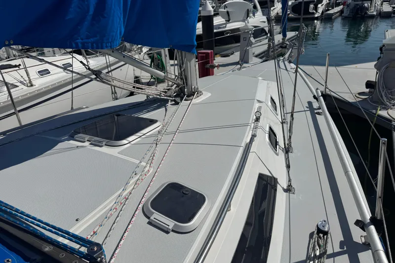 Slide: The Image of 1994 Catalina 320 sailboat deck with blue sail cover, docked in marina. - 23