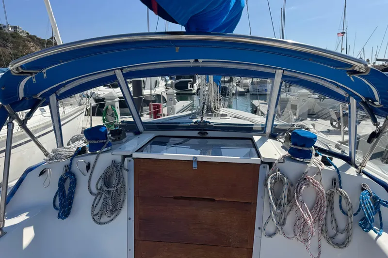 Slide: The Image of 1994 Catalina 320 sailboat cockpit with blue canopy and neatly coiled ropes. - 24