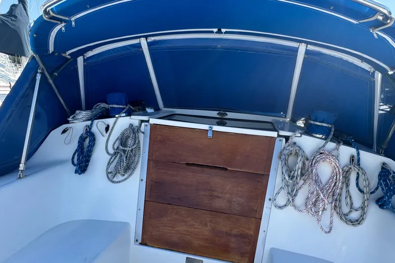 Slide: The Image of Interior view of a 1994 Catalina 320 sailboat with blue canopy and coiled ropes. - 25