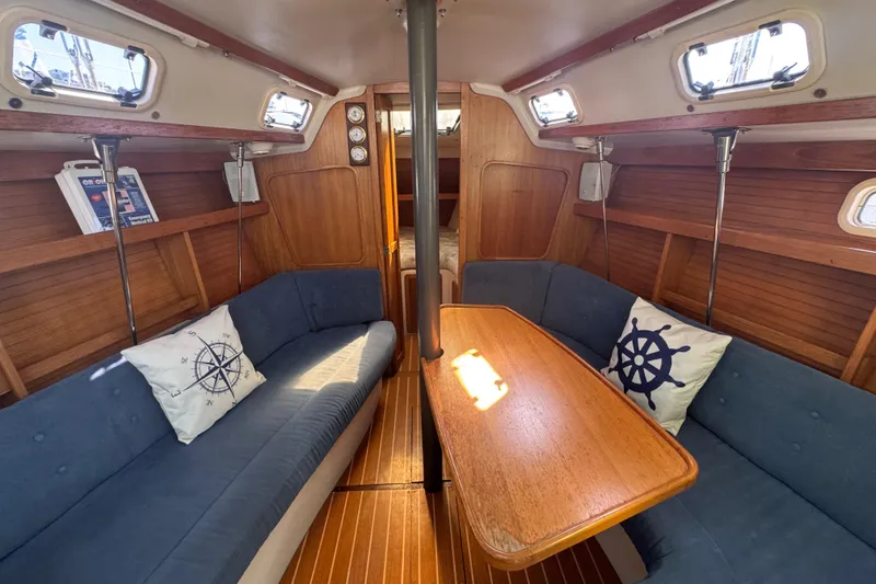 Slide: The Image of Cozy interior of a 1994 Catalina 320 sailboat with blue seating and wooden accents. - 29
