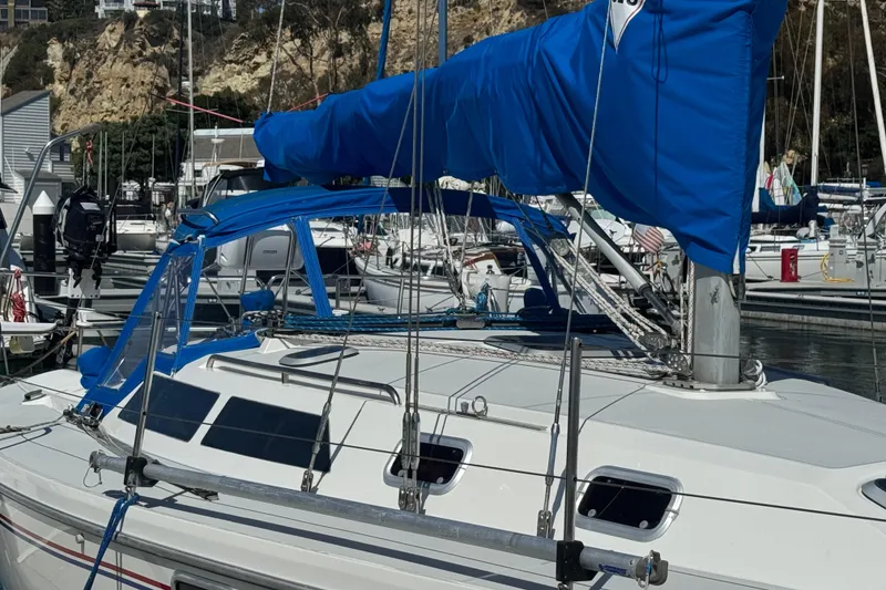 Slide: The Image of 1994 Catalina 320 sailboat docked in marina with blue sail cover. - 3