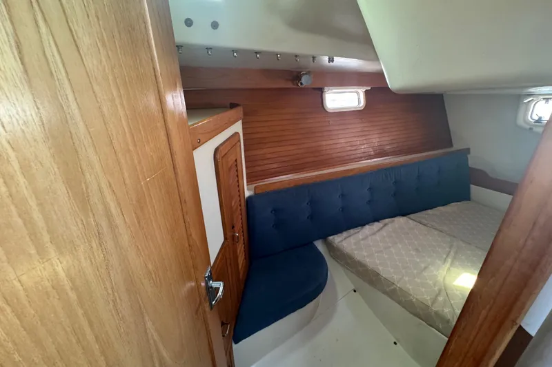 Slide: The Image of Cozy cabin interior of a 1994 Catalina 320 sailboat with wooden accents and blue seating. - 34