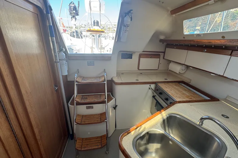 Slide: The Image of Interior of a 1994 Catalina 320 sailboat with kitchen and stairs. - 38