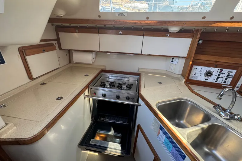 Slide: The Image of Compact kitchen in a 1994 Catalina 320 sailboat with stove, sink, and storage. - 40