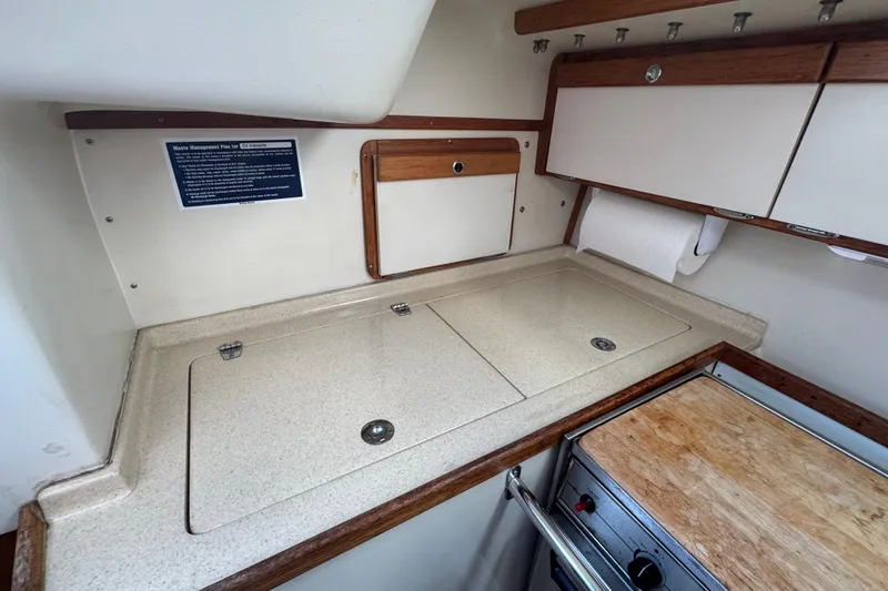 Slide: The Image of Catalina 320 (1994) yacht kitchen with countertop, stove, and storage cabinets. - 41