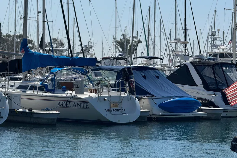 Slide: The Image of Catalina 320 sailboat from 1994 docked at a marina, surrounded by other boats. - 51