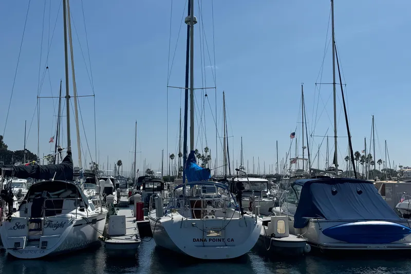 Slide: The Image of Boats docked at a marina, featuring a 1994 Catalina 320 sailboat. - 52