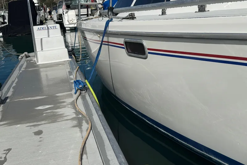 Slide: The Image of Catalina 320 sailboat docked, 1994 model, with red and blue stripes, marina setting. - 7