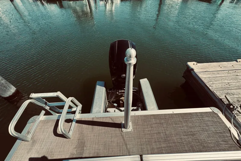 Slide: The Image of 2017 Sun Tracker Party Barge 22 DLX at dock, rear view with motor and ladder. - 6