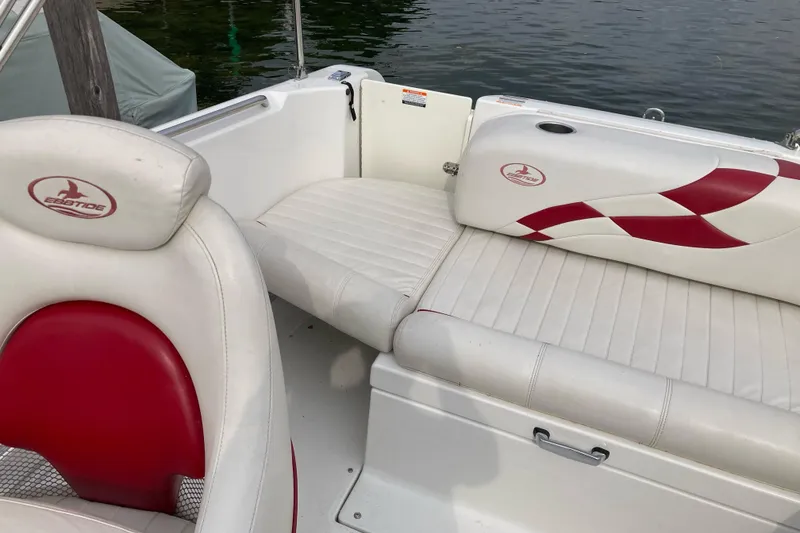 Slide: The Image of 2005 Ebbtide 2400 Fun Cruiser DC boat interior with red and white seating by the water. - 11