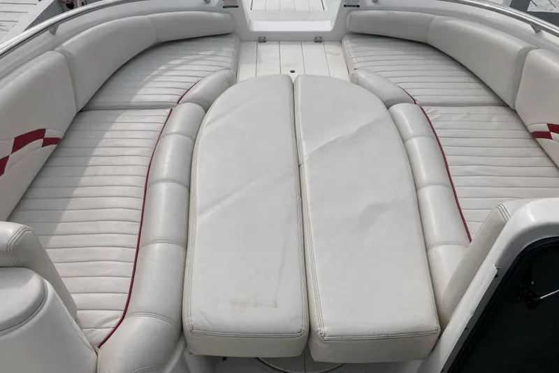 Slide: The Image of 2005 Ebbtide 2400 Fun Cruiser DC boat interior with white cushioned seating. - 14