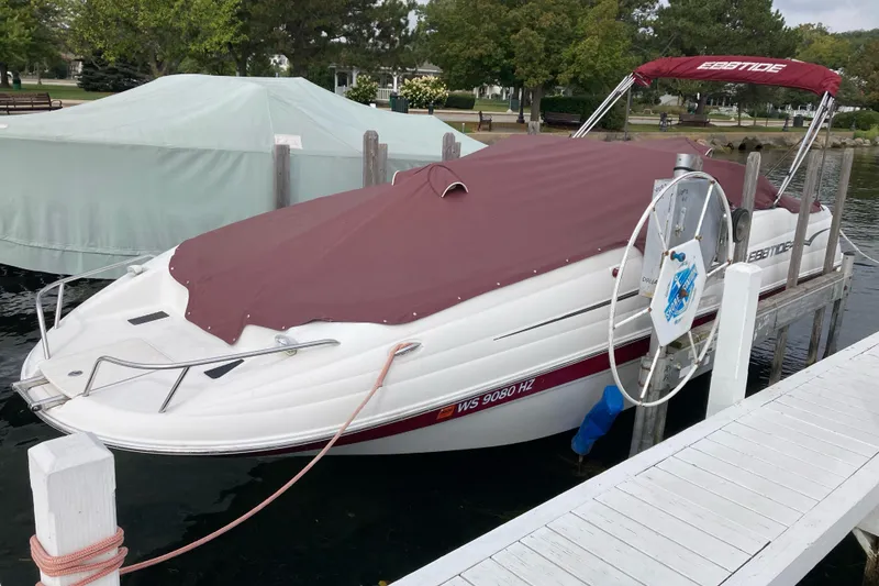 Slide: The Image of 2005 Ebbtide 2400 Fun Cruiser DC boat docked with maroon cover. - 4