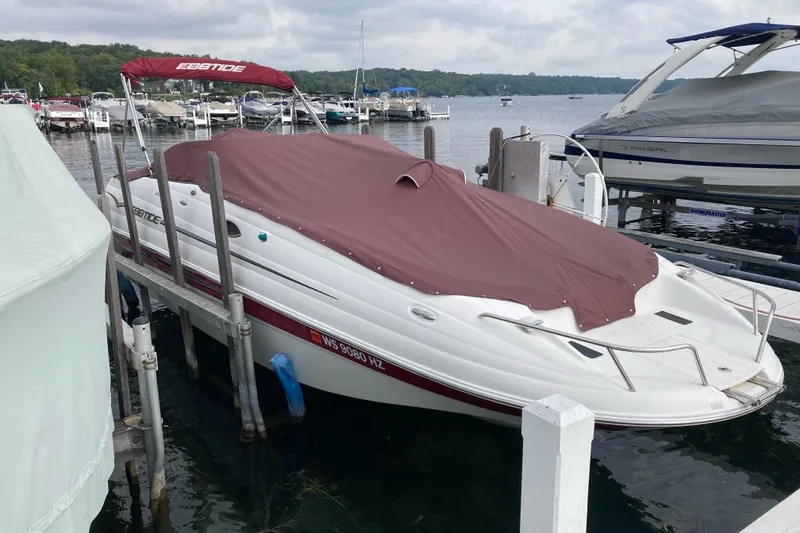 Slide: The Image of 2005 Ebbtide 2400 Fun Cruiser DC boat docked with cover on a lake. - 6